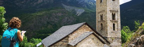 Senderista junto a iglesia románica en Pirineos